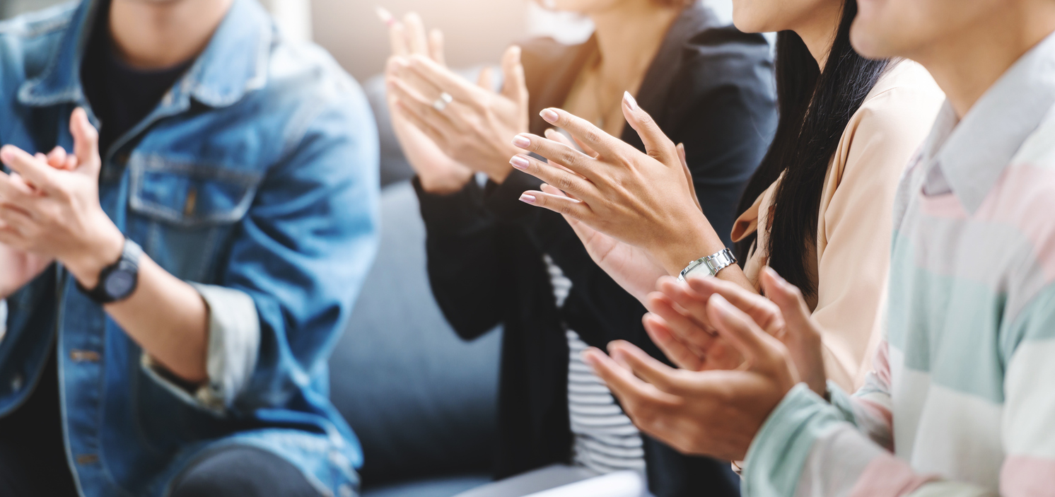 support and recognition for overcoming eating disorder challenges- hands clapping congratulating an OA member at an in person meeting